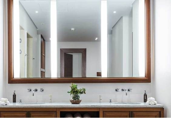 Bathroom with a wall-mounted mirror and tiled surround